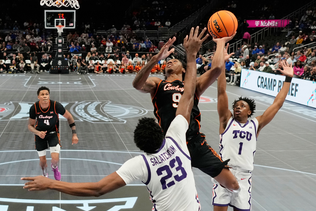 Oklahoma State guard Anthony Roy (9) shoots over TCU center Vianney Salatchoum (23) during the first half of an NCAA college basketball game in the second round of the Big 12 Conference tournament Wednesday, March 11, 2026, in Kansas City, Mo. (AP Photo/Charlie Riedel)