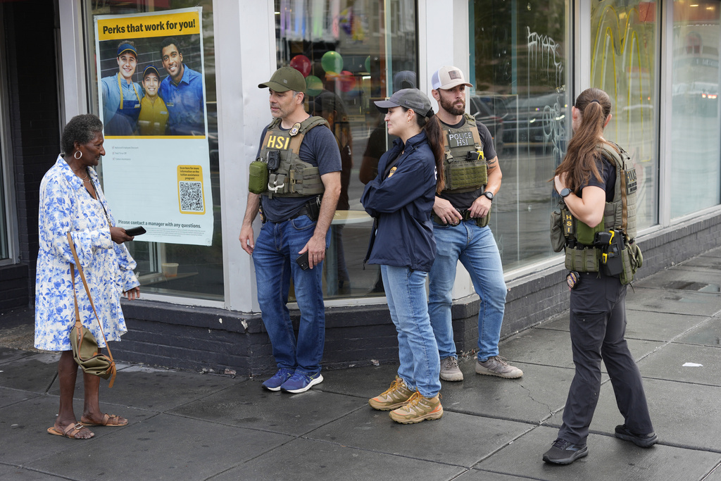 Department of Homeland Security Investigation officers stop to talk to a member of the community at the intersection of 14th and U Streets in northwest Washington, while on patrol Wednesday, Aug. 13, 2025. (AP Photo/Pablo Martinez Monsivais)