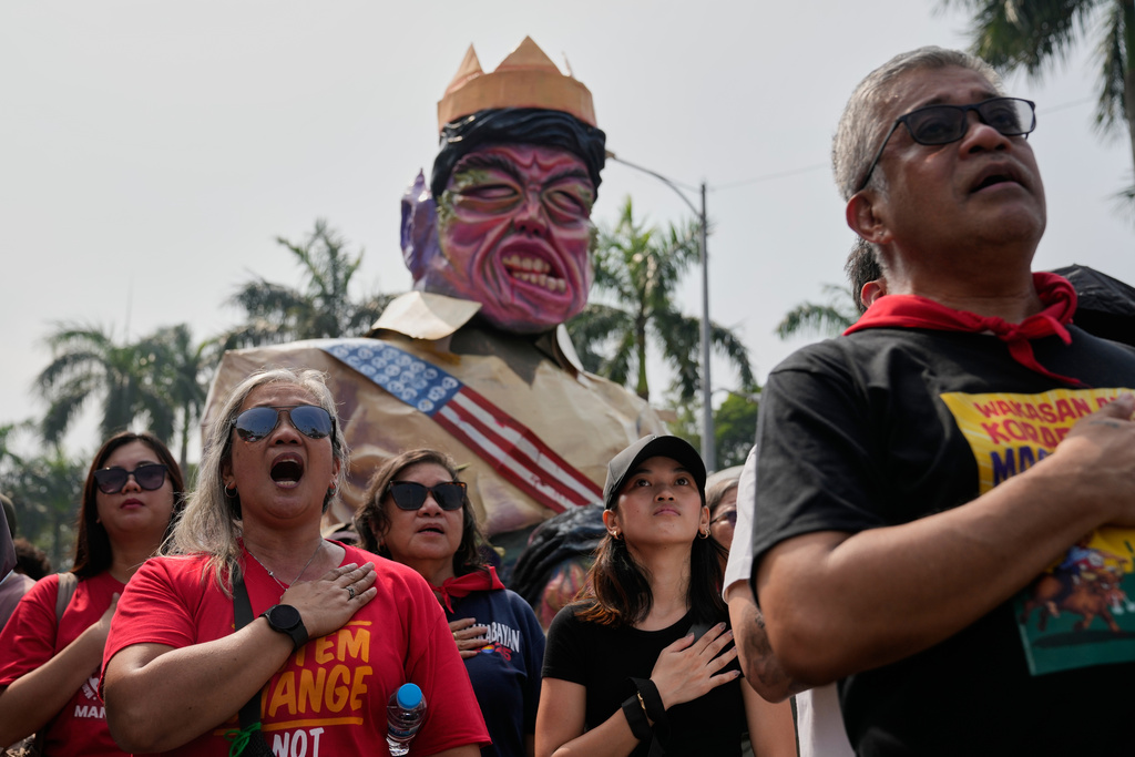 Protesters sing the national anthem with the effigy of President Ferdinand Marcos Jr., seen at rear, during anti-corruption protest in Manila, Philippines on Sunday Nov. 30, 2025. (AP Photo/Aaron Favila)