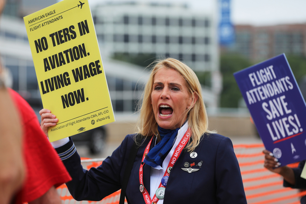 Sara Nelson, the international president of the Association of Flight Attendants-CWA, holds placard during a demonstration at Ronald Reagan Washington National Airport, Monday, August 18, 2025, in Washington. (AP Photo/Rahmat Gul)