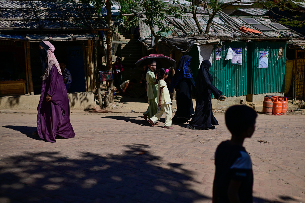 FILE - Rohingya refugee women and children walk along a street in the Rohingya refugee camp in Cox's Bazar, Bangladesh, Nov. 21, 2025. (AP Photo/Mahmud Hossain Opu, File)