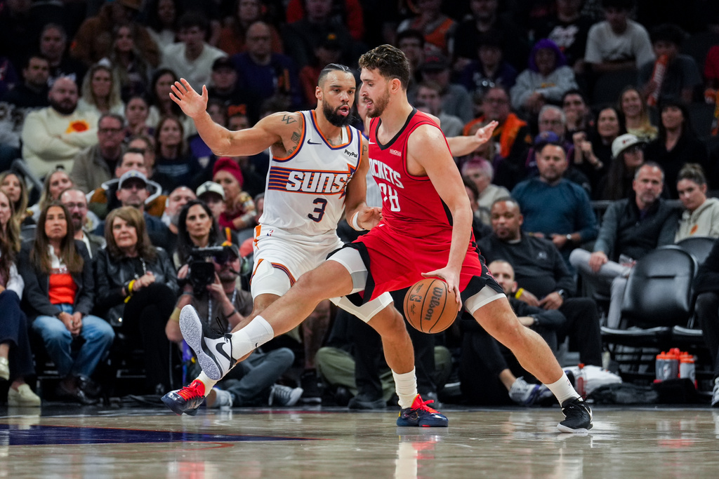 Houston Rockets center Alperen Sengun (28) dribbles the ball in front of Phoenix Suns forward Dillon Brooks (3) during the first half of an NBA basketball game, Monday, Nov. 24, 2025, in Phoenix. (AP Photo/Samantha Chow)