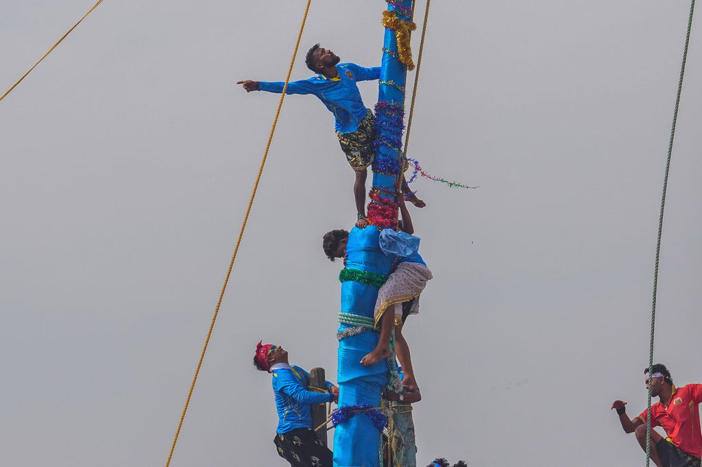 Members of the Agri-Koli community compete to erect ceremonial bamboo poles in a centuries-old annual tradition honoring the local goddess Raiba Devi, in Rave village near Mumbai, India, Friday, April 17, 2026. (AP Photo/Rafiq Maqbool)