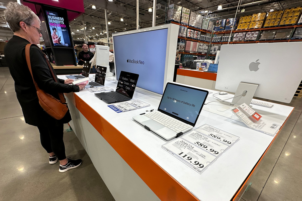 FILE - A shopper looks over Apple MacBook laptops on display in a Costco warehouse on June 2, 2026, in Sheridan, Colo. (AP Photo/David Zalubowski, File)