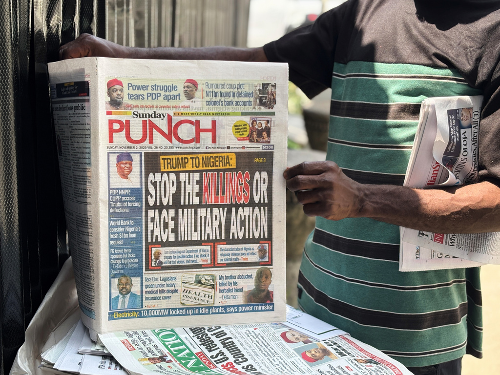 A vendor sells local newspapers with headlines referring to US President Donald Trump's comments about Nigeria, on the street of Lagos, Nigeria, Sunday, Nov. 2, 2025. (AP Photo/Sunday Alamba)