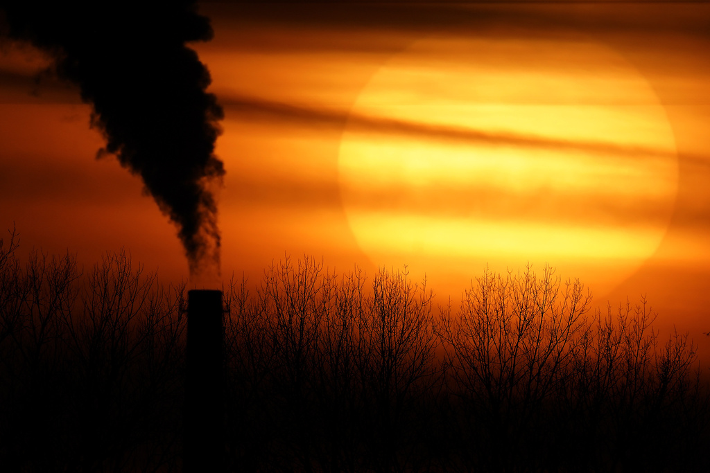 FILE - Emissions from a coal-fired power plant are silhouetted against the setting sun in Kansas City, Mo., Feb. 1, 2021. (AP Photo/Charlie Riedel, File)