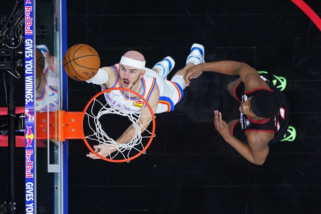 Oklahoma City Thunder's Alex Caruso, left, goes up for a shot against Philadelphia 76ers' Vj Edgecombe during the first half of an NBA basketball game Monday, March 23, 2026, in Philadelphia. (AP Photo/Matt Slocum)