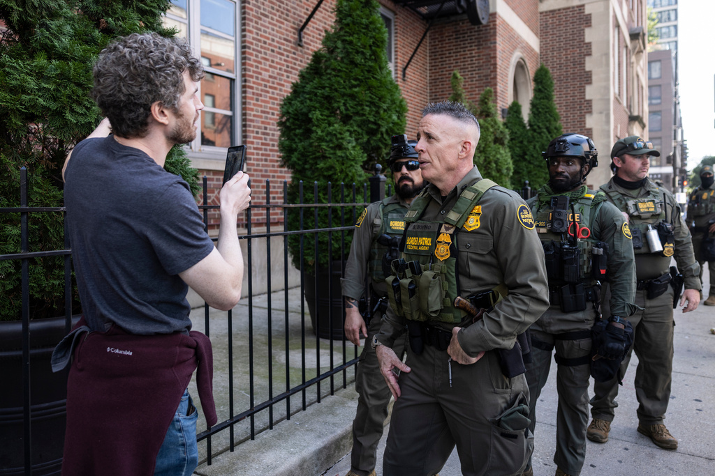 Greg Bovino, the chief patrol agent for the U.S. Border Patrol El Centro sector, asks a pedestrian their birth country as the pedestrian films federal agents detaining a man who took off running away from them as they were walking on North Clark Street near West Superior Street in the River North neighborhood, Sunday, Sept. 28, 2025, in Chicago. (Ashlee Rezin/Chicago Sun-Times via AP)
