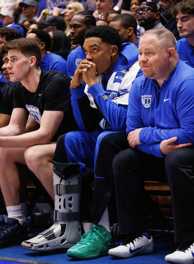 Duke's Caleb Foster sits on the bench wearing a boot after suffering an injury during the first half of an NCAA college basketball game against North Carolina in Durham, N.C., Saturday, March 7, 2026. (AP Photo/Ben McKeown)