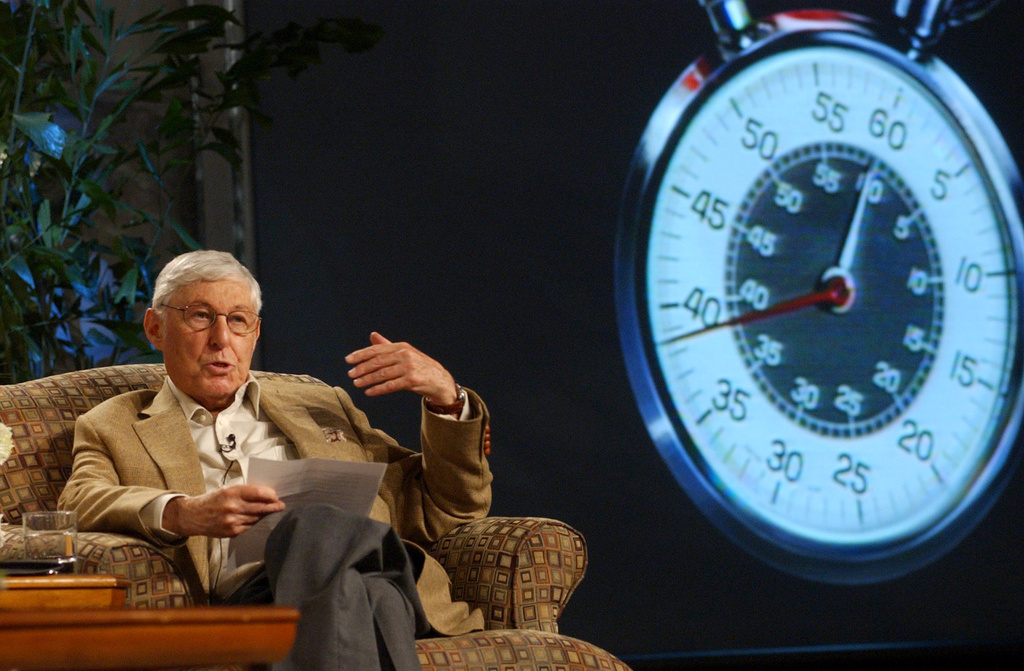 FILE - Against a backdrop of the famous "60 Minutes" stop watch, Don Hewitt, the program's creator and executive producer, reads prepared remarks to reporters during a session on "60 Minutes" during CBS' Winter Press Tour in the Hollywood section of Los Angeles, Jan. 17, 2004. (AP Photo/Rene Macura, File)