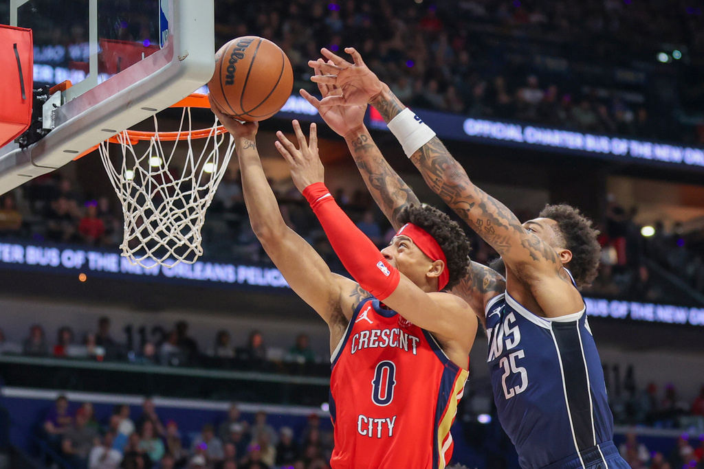 New Orleans Pelicans guard Jeremiah Fears (0) shoots a layup against Dallas Mavericks forward P.J. Washington (25) in the first half of an NBA basketball game Monday, Dec. 22, 2025, in New Orleans. (AP Photo/Peter Forest)