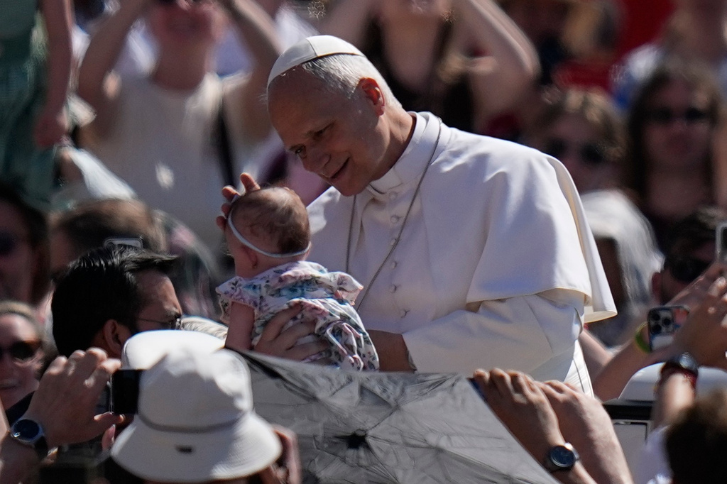 Pope Leo XIV blesses a new born as he arrives for his weekly general audience in St. Peter's Square at The Vatican, Wednesday, May 27, 2026. (AP Photo/Alessandra Tarantino)