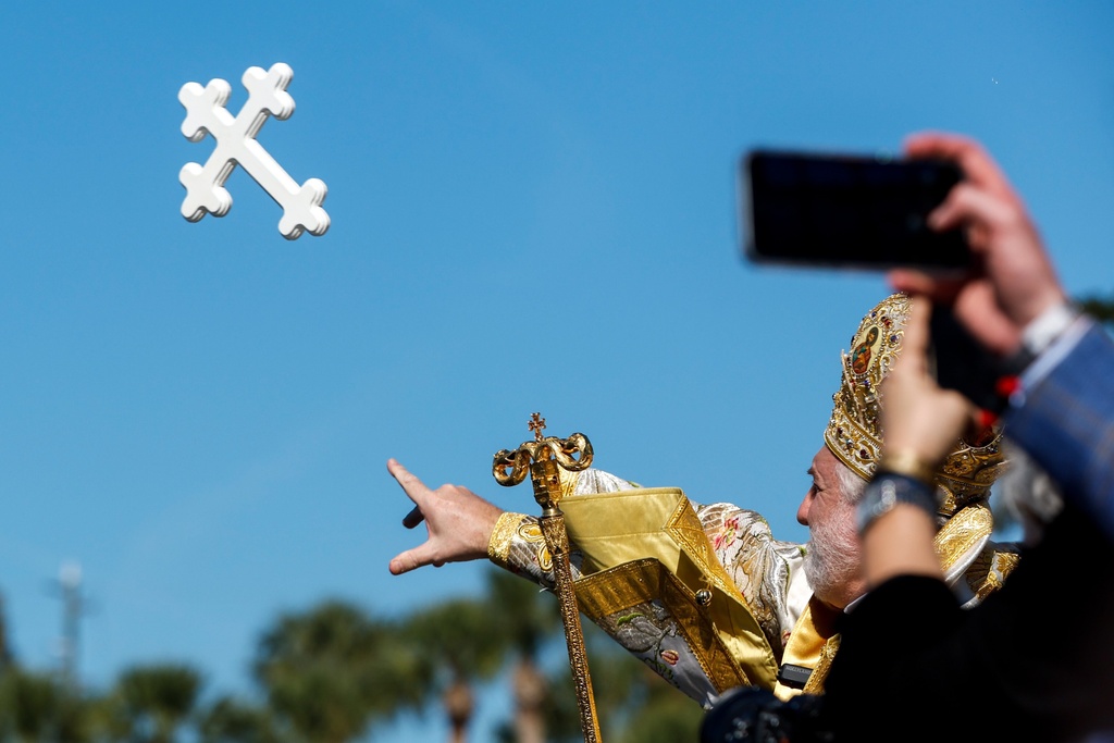His Eminence Archbishop Elpidophoros of the Greek Orthodox Archdiocese of America tosses the cross into the water during the annual cross dive in the Spring Bayou, part of the Epiphany celebration on Tuesday, Jan. 6, 2026, in Tarpon Springs, Fla. (Jefferee Woo /Tampa Bay Times via AP)