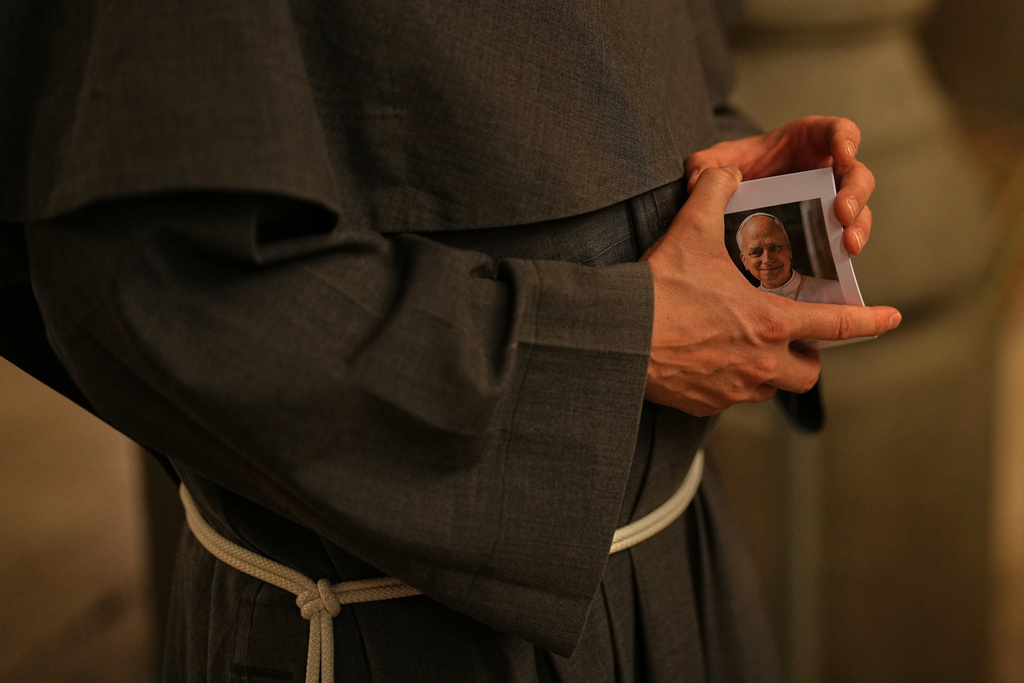 Christian Catholic priest Father Andrew holds photographs of Pope Leo XIV following a mass at St. Anthony of Padua Catholic church, in Istanbul, Turkey, Tuesday, Nov. 18, 2025, ahead of the visit of Pope Leo XIV to Turkey. (AP Photo/Francisco Seco)