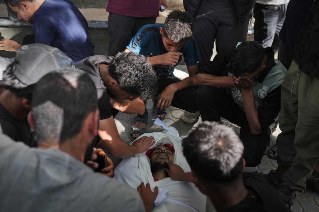 Mourners gather around the bodies of Palestinians killed in an Israeli strike, during their funeral in Shifa Hospital in Gaza City, Sunday, June 14, 2026. (AP Photo/Jehad Alshrafi)