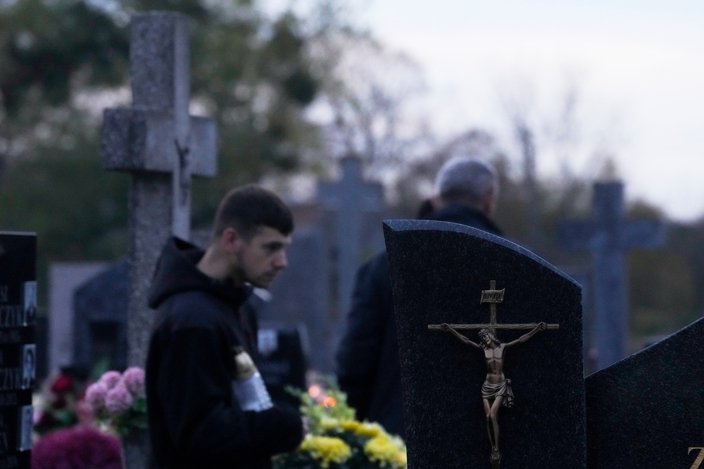 A men observe All Saints' Day, a time for reflecting on those who have died, in Kroczewo near Warsaw, Poland, Saturday, Nov. 1, 2025. (AP Photo/Czarek Sokolowski)