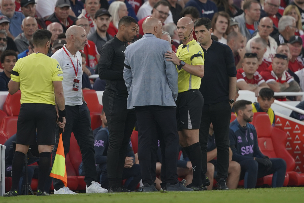 Referee Anthony Taylor speaks with Liverpool manager Arne Slot, center, and Bournemouth manager Andoni Iraola, right, after Bournemouth's Antoine Semenyo, not pictured, informed the referee of a possible racial comment from the crowd during the English Premier League soccer match between Liverpool and Bournemouth at Anfield stadium in Liverpool, England, Friday, Aug. 15, 2025. (AP Photo/Ian Hodgson)