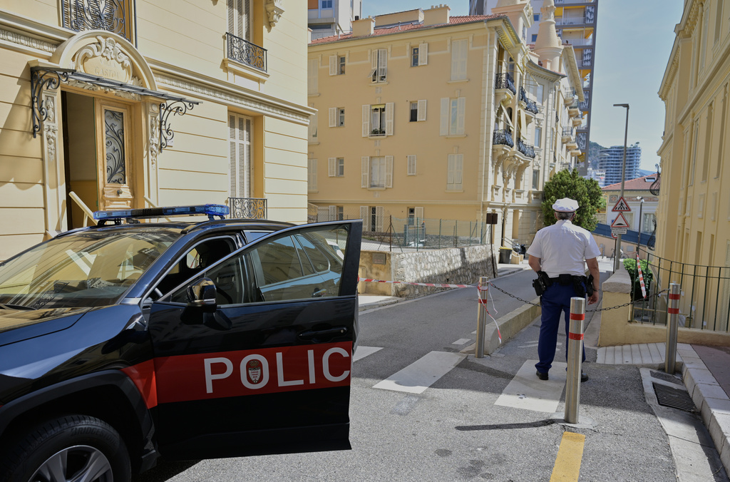 A police officer guards in a street in Monaco, Tuesday, June 30, 2026, a day after an explosive device seriously injured three people at a residential building in Monaco. (AP Photo/Philippe Magoni)