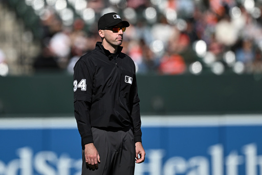 FILE - Umpire Nate Tomlinson looks on during a baseball game between the Baltimore Orioles and the Toronto Blue Jays in Baltimore, April 13, 2025. (AP Photo/Terrance Williams, File) FILE - Umpire Nate Tomlinson looks on during a baseball game between the Baltimore Orioles and the Toronto Blue Jays in Baltimore, April 13, 2025. (AP Photo/Terrance Williams, File)