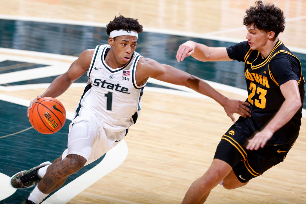 Michigan State guard Jeremy Fears Jr. (1), left, drives against Iowa guard Isaia Howard (23) during the first half of an NCAA college basketball game, Tuesday, Dec. 2, 2025, in East Lansing, Mich. (AP Photo/Al Goldis)