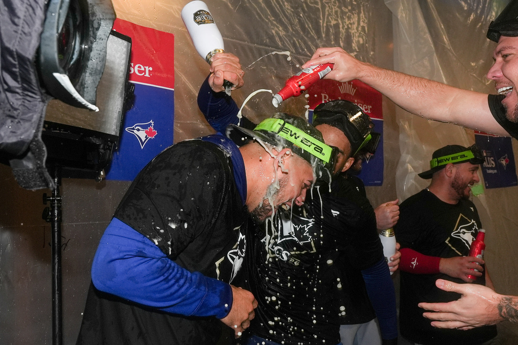 The Toronto Blue Jays celebrate in the locker room after defeating the New York Yankees in Game 4 of baseball's American League Division Series, Wednesday, Oct. 8, 2025, in New York. (AP Photo/Frank Franklin II)