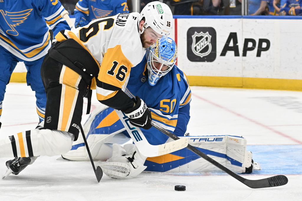 St. Louis Blues goaltender Jordan Binnington (50) defends the net from Pittsburgh Penguins right wing Justin Brazeau (16) during the first period of an NHL hockey game Tuesday, April 14, 2026, in St. Louis. (AP Photo/Jeff Le)
