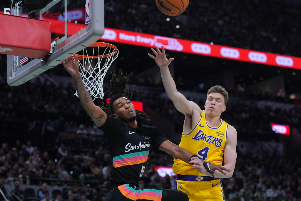San Antonio Spurs guard Stephon Castle (5) and Los Angeles Lakers forward Dalton Knecht (4) reach for a rebound during the first half of an NBA basketball game in San Antonio, Wednesday, Jan. 7, 2026. (AP Photo/Eric Gay)