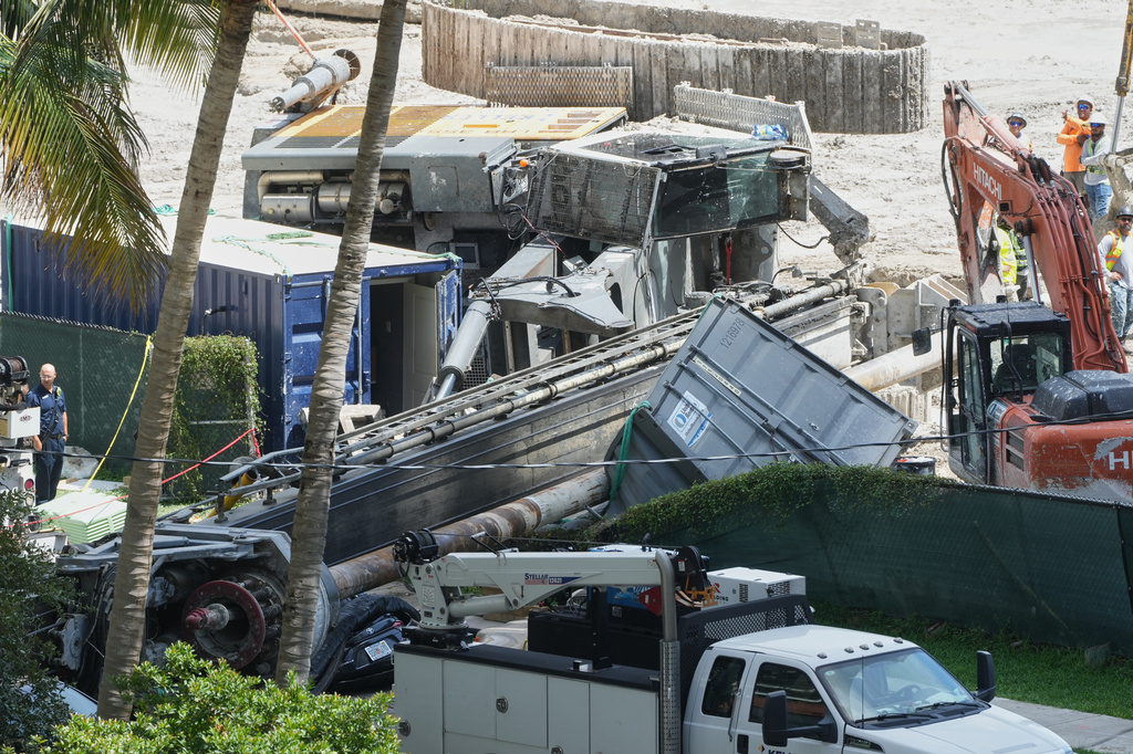 A person stands beside a large construction crane after it collapsed, Monday, Sept. 14, 2026, in Miami. (AP Photo/Marta Lavandier)