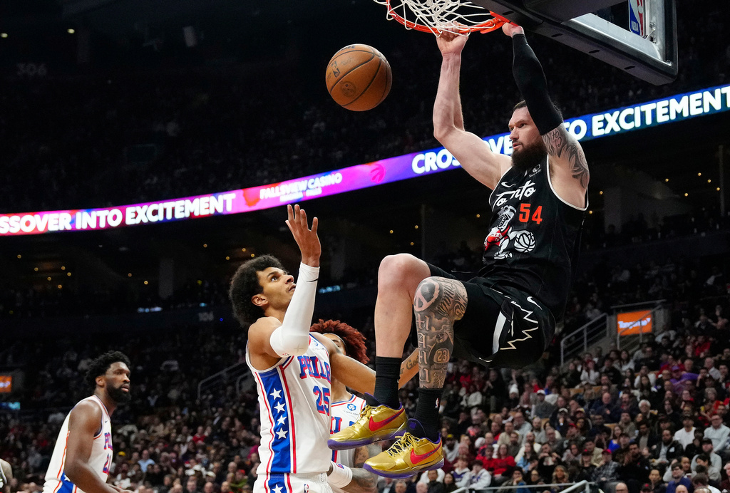 Toronto Raptors forward/center Sandro Mamukelashvili (54) dunks over Philadelphia 76ers forward Dominick Barlow (25) during the first half of an NBA basketball game in Toronto, Monday, Jan. 12, 2026. (Frank Gunn/The Canadian Press via AP)