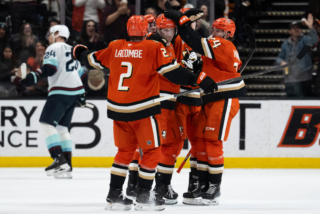 Anaheim Ducks defenseman Jacob Trouba (65) celebrates his goal with defenseman Jackson LaCombe (2) and center Jansen Harkins (24) during the second period of an NHL hockey game against the Seattle Kraken Tuesday, Feb. 3, 2026, in Anaheim, Calif. (AP Photo/Kyusung Gong)