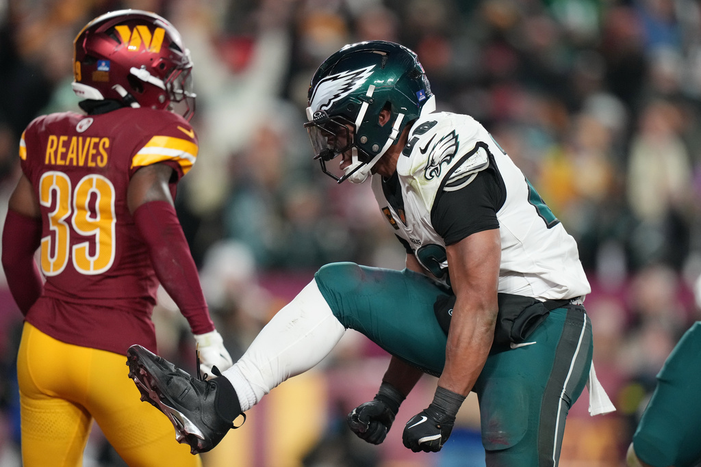 Philadelphia Eagles running back Saquon Barkley, right, celebrates after a touchdown against the Washington Commanders during the second half of an NFL football game, Saturday, Dec. 20, 2025, in Landover, Md. (AP Photo/Stephanie Scarbrough)