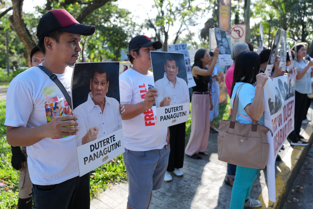 Activists hold pictures of former Philippine President Rodrigo Duterte during a rally before they watch a live stream of Duterte's confirmation hearing from The Hague, at a venue in Quezon City, Philippines on Monday, Feb. 23, 2026. Sign reads "Hold Duterte accountable."(AP Photo/Aaron Favila)