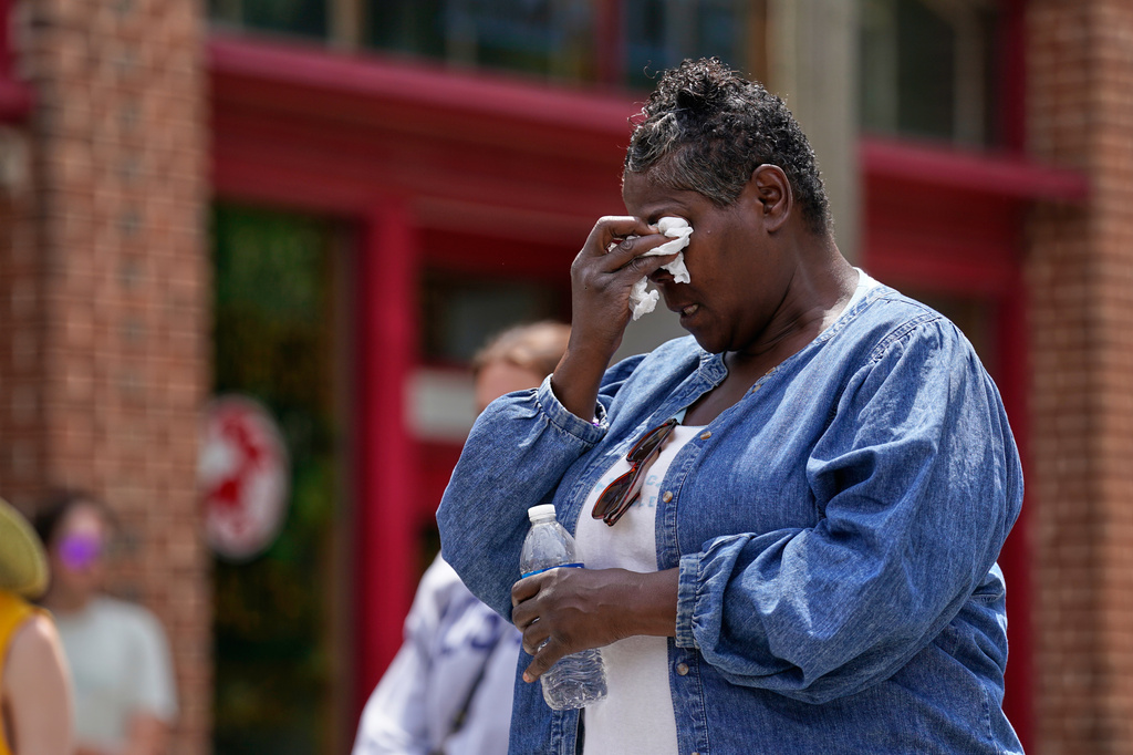 Mourners gather around a memorial at the site where a man was shot and killed on Wednesday by Madison police, Thursday, July 23, 2026, in Madison, Wis. (AP Photo/Kayla Wolf)