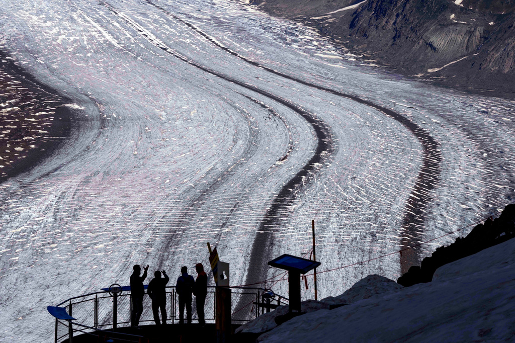 FILE — People enjoy the view at the Aletsch Glacier near Goms, Switzerland, June 14, 2023. (AP Photo/Matthias Schrader, File)