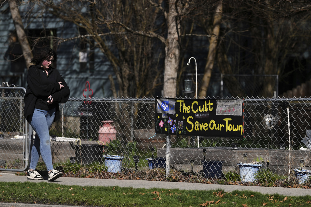 A person walks by a house displaying a sign against Christ Church and its founder and pastor Douglas Wilson, Saturday, April 5, 2025, in Moscow, Idaho. (AP Photo/Lindsey Wasson)