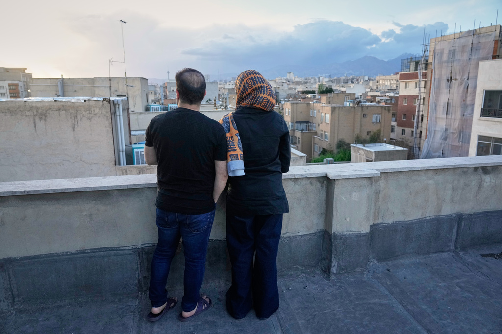 Zahra Arghavan, right, and Mehdi Alishir look out over the city from the rooftop of their apartment in Tehran, Iran, Sunday, April 5, 2026. (AP Photo/Vahid Salemi)