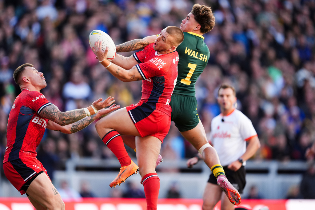 England's Tom Johnstone (left) and Mikey Lewis combine to tackle Australia's Reece Walsh (centre) during the rugby League Ashes series match between England and Australia, in Leeds, England, Saturday Nov. 8, 2025. (Mike Egerton/PA via AP)