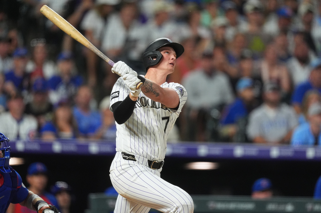 Colorado Rockies' TJ Rumfield follows the flight of his two-run home run off Chicago Cubs relief pitcher Jacob Webb in the eighth inning of a baseball game Wednesday, June 10, 2026, in Denver. (AP Photo/David Zalubowski)
