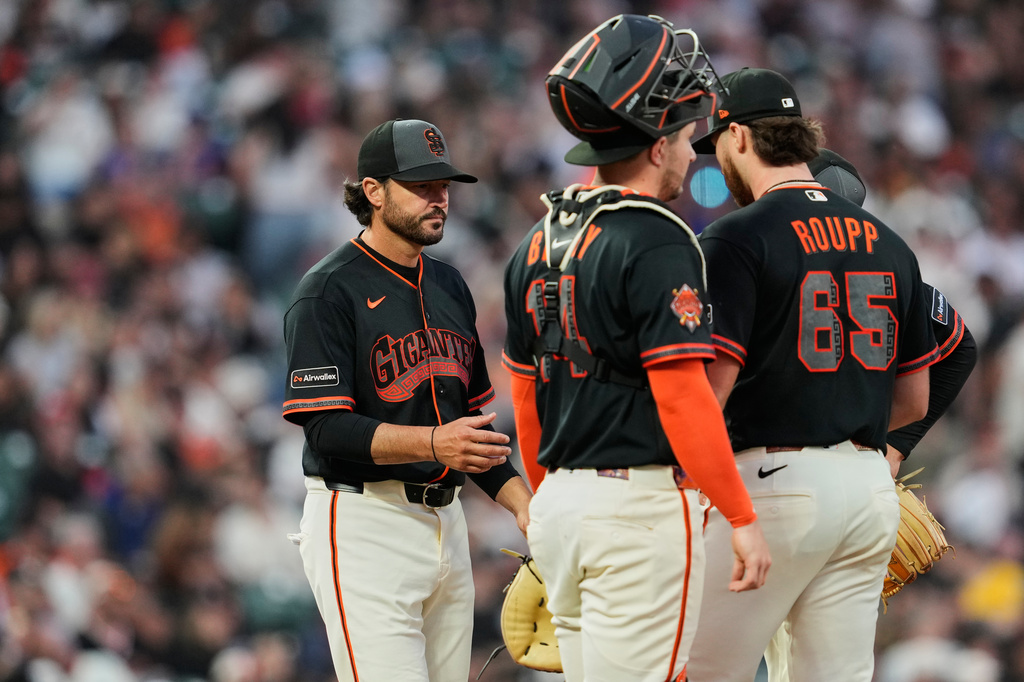 San Francisco Giants pitcher Landen Roupp (65) hands the ball over to manager Tony Vitello, left, as he exits during the fifth inning of a baseball game against the New York Mets, Saturday, April 4, 2026, in San Francisco. (AP Photo/Godofredo A. Vásquez)