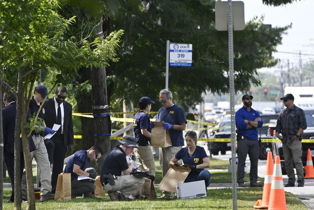 Investigators from the FBI survey the scene where an Immigration and Customs Enforcement officer shot and killed a suspect after the suspect drove his car at the arresting officers, Friday, Sept. 12, 2025, in Franklin Park, Ill. (AP Photo/Paul Beaty)