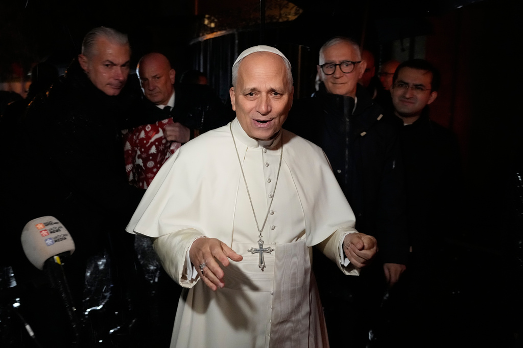 Pope Leo XIV talks to journalists as he leaves the Castel Gandolfo residence to head to the Vatican, Tuesday, Dec. 23, 2025. (AP Photo/Gregorio Borgia)