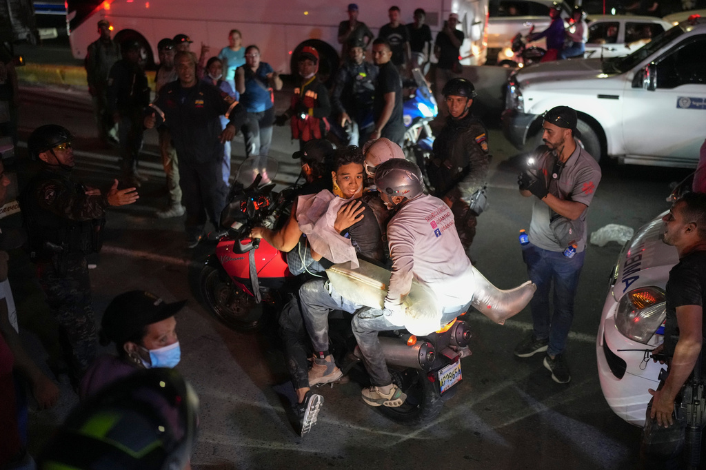 A youth rescued from the debris is taken away on a motorcycle two days after earthquakes struck La Guaira, Venezuela, Friday, June 26, 2026. (AP Photo/Matias Delacroix)