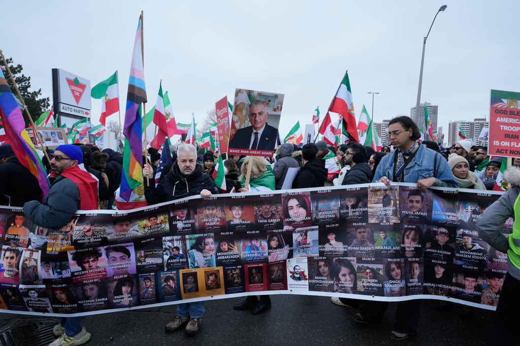 Supporters of Iran's exiled Crown Prince Reza Pahlavi carry a banner presenting the people were killed in Iran during recent uprising, while attending a demonstration in Toronto, Saturday, Feb. 14, 2026. (AP Photo/Kamran Jebreili)