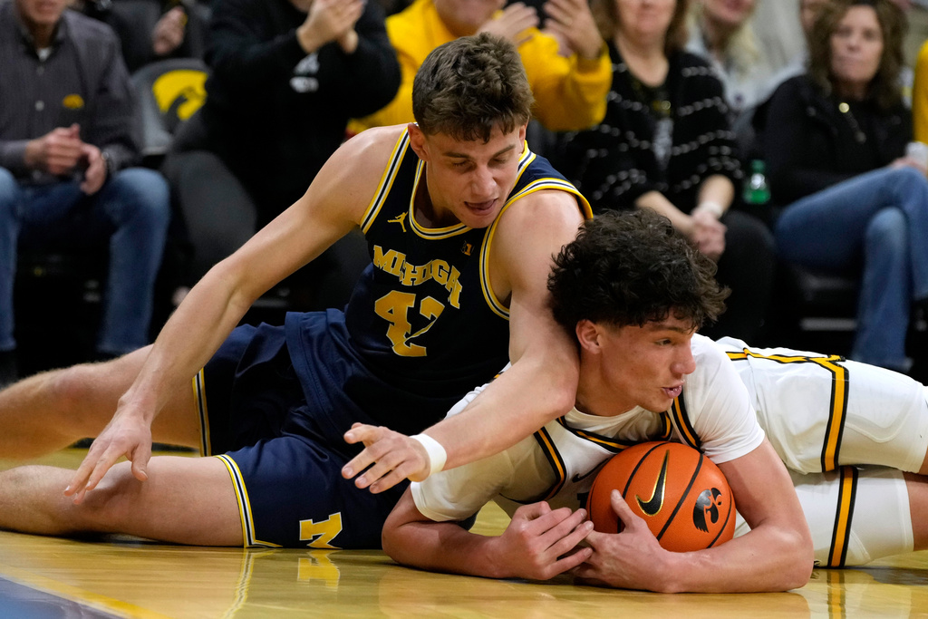 Michigan forward Will Tschetter (42) fights for a loose ball with Iowa guard Isaia Howard, right, during the first half of an NCAA college basketball game, Thursday, March 5, 2026, in Iowa City, Iowa. (AP Photo/Charlie Neibergall)