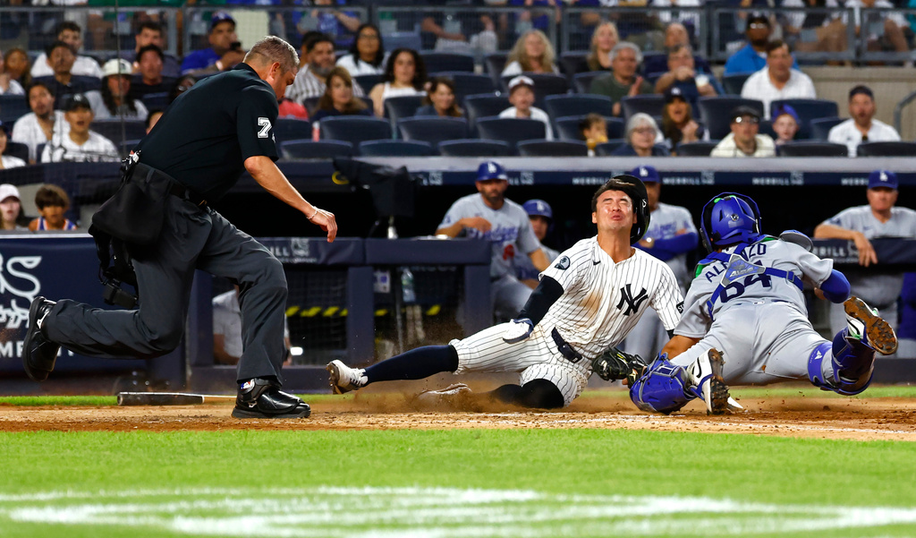 New York Yankees' Anthony Volpe, center, is tagged out by Los Angeles Dodgers catcher Eliezer Alfonzo, right, during the fourth inning of the second game of a baseball doubleheader, Sunday, July 19, 2026, in New York. (AP Photo/Noah K. Murray)