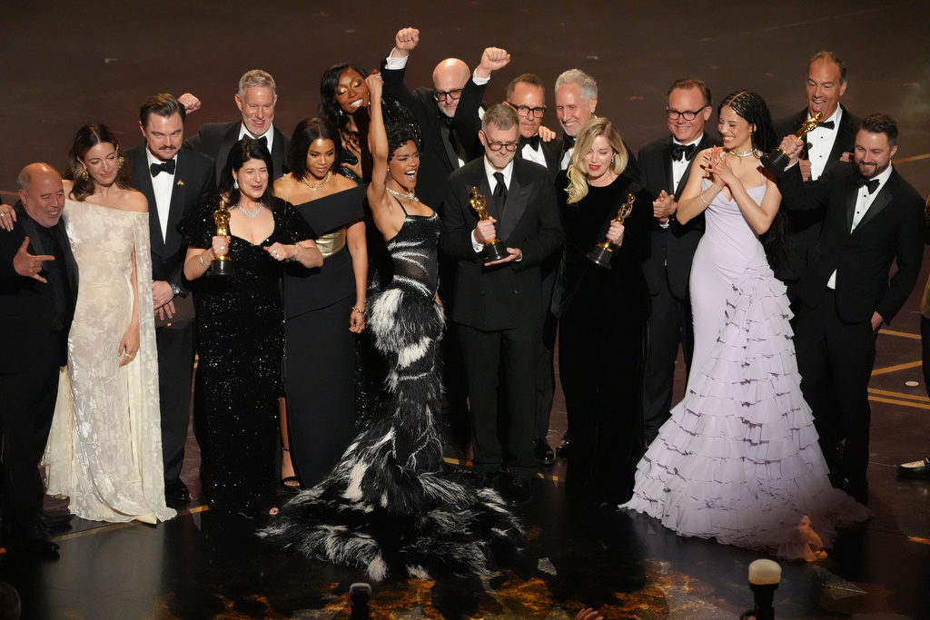 Jose Antonio Garcia, from left, Florencia Martin, Leonardo DiCaprio, Cassandra Kulukundis, Regina Hall, Shayna McHale, Teyana Taylor, Michael Bauman, Paul Thomas Anderson, Anthony Carlino, Will Weike, Sara Murphy, Chase Infiniti, Christopher Scarabosio, and Andy Jurgensen accept the award for best picture award for "One Battle After Another" during the Oscars on Sunday, March 15, 2026, at the Dolby Theatre in Los Angeles. (AP Photo/Chris Pizzello)