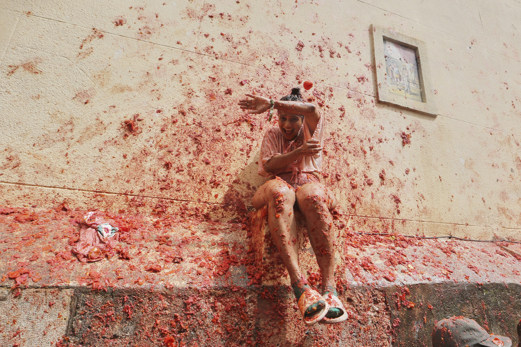 Revelers throw tomatoes at each other during the annual "Tomatina" tomato fight fiesta, in the village of Bunol near Valencia, Spain, Wednesday, Aug. 27, 2025. (AP Photo/Alberto Saiz)