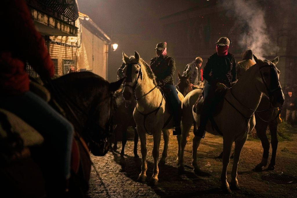 Riders on their horses wait to jump over the bonfires as part of a ritual in honor of Saint Anthony the Abbot, the patron saint of domestic animals, in San Bartolome de Pinares, Spain, Friday, Jan. 16, 2026. (AP Photo/Manu Fernandez)