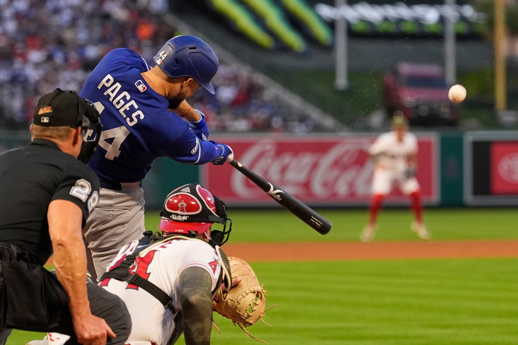 Los Angeles Dodgers' Andy Pages, center, hits a three-run home run as Los Angeles Angels catcher Logan O'Hoppe, right, and home plate umpire Jim Wolf watch during the fourth inning of a baseball game Friday, May 15, 2026, in Anaheim, Calif. (AP Photo/Mark J. Terrill)
