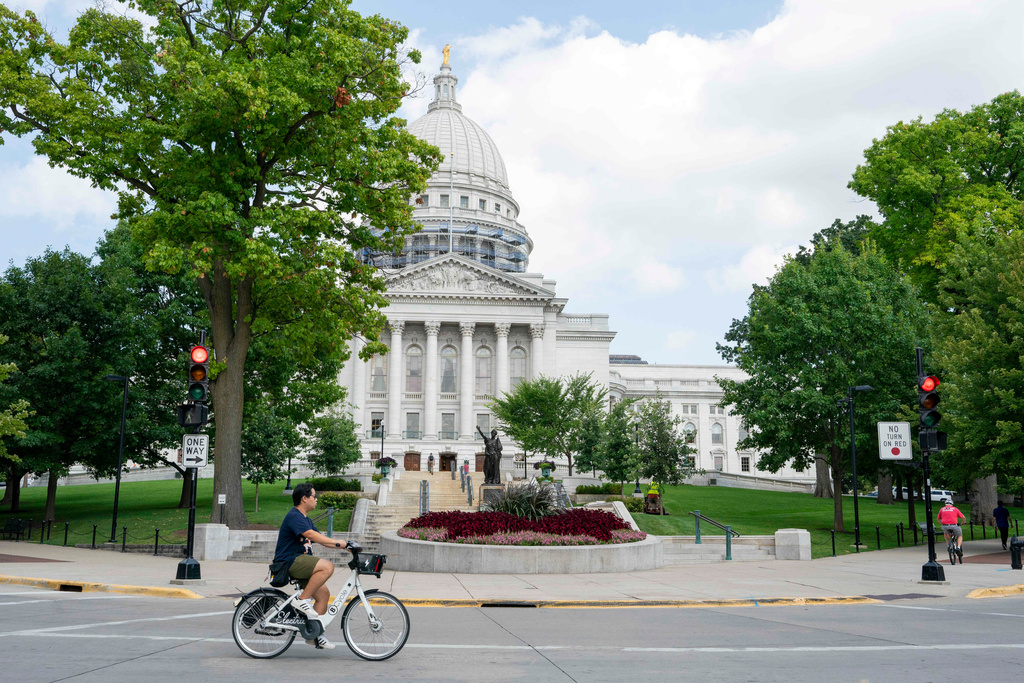 FILE - A cyclist rides past the Wisconsin State Capitol July 30, 2024, in Madison, Wis. (AP Photo/Kayla Wolf, File)